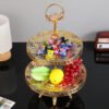 This luxurious 2-tier serving stand is a masterpiece of functional decor, designed to bring a regal touch to any table setting. With its intricate gold-plated metalwork and clear glass surfaces, it offers a sophisticated way to display pastries, appetizers, or jewelry.